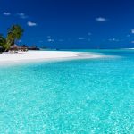 Palm trees over stunning lagoon and white beach