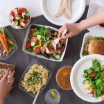 Overhead of hands serving up food at party